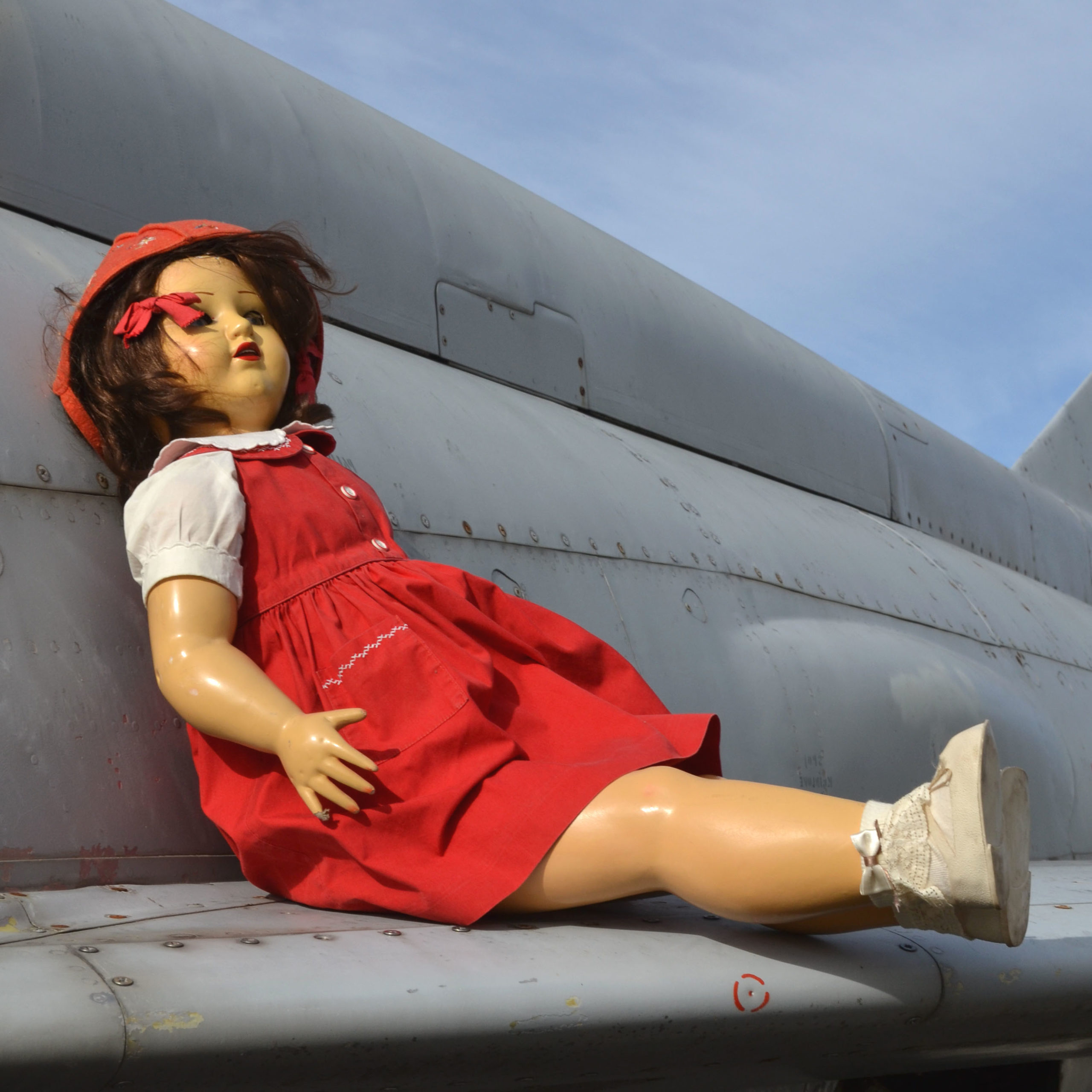 ancienne grande poupée marcheuse des années 1940 en papier mâché, de fabrication Suisse. avec robe tablier rouge.