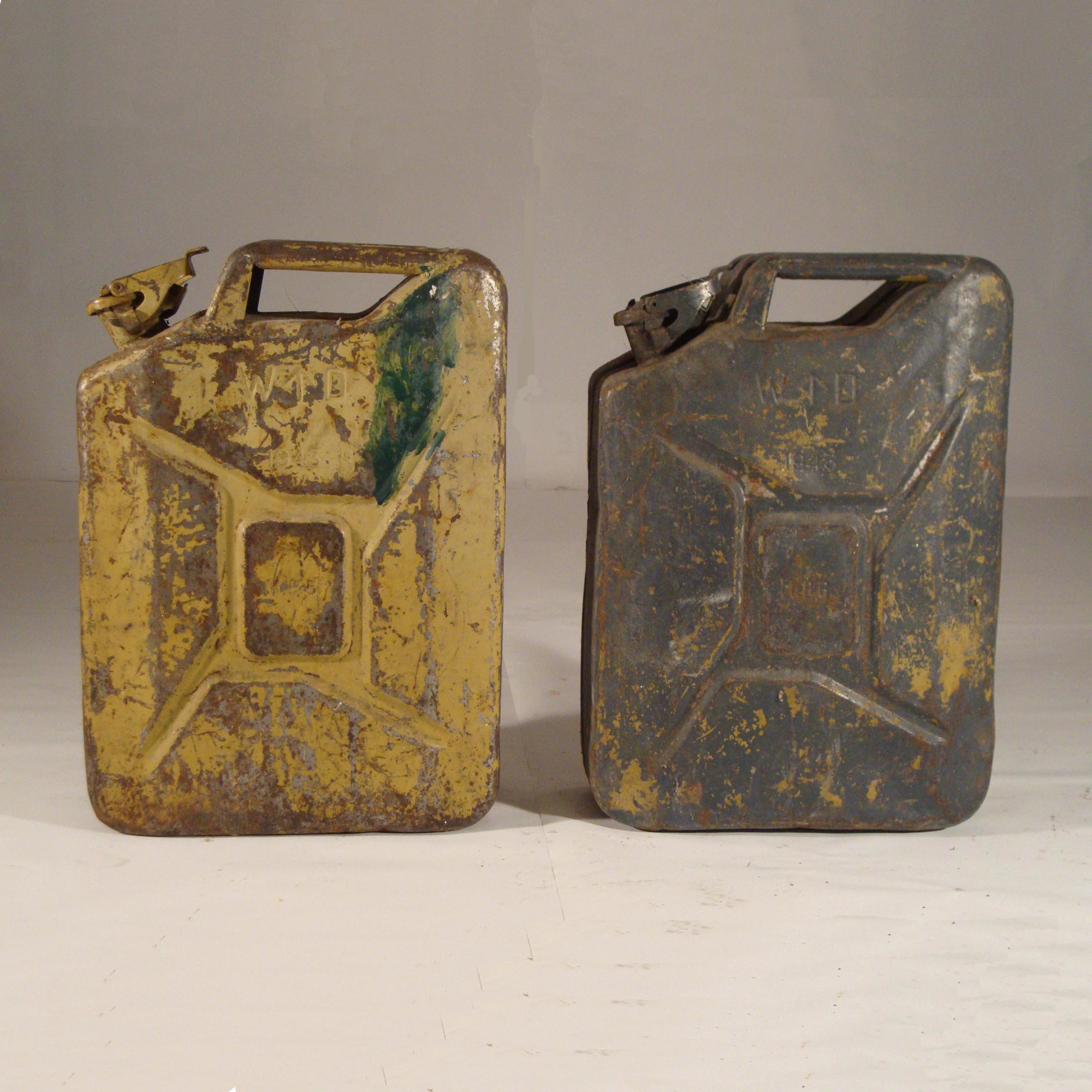 Jerrycans Anglais couleur jaune sable, tout les 2 datés de 1943, marquage W.D. (pour War Departement) la flèche symbolise le “broken arrow”