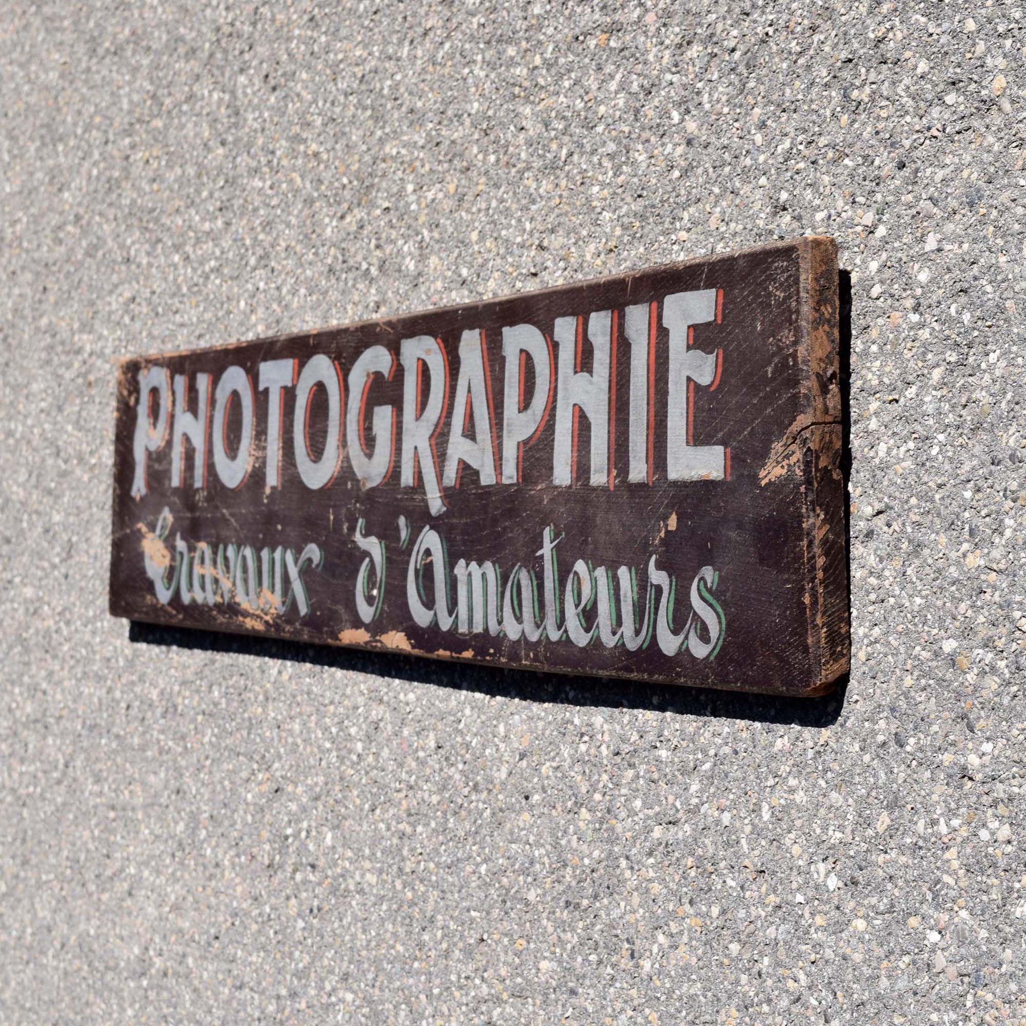 Mignonne petite enseigne de photographe: “Photographie travaux d’amateurs” Typo assez ancienne. Lettrage peint à la main.
