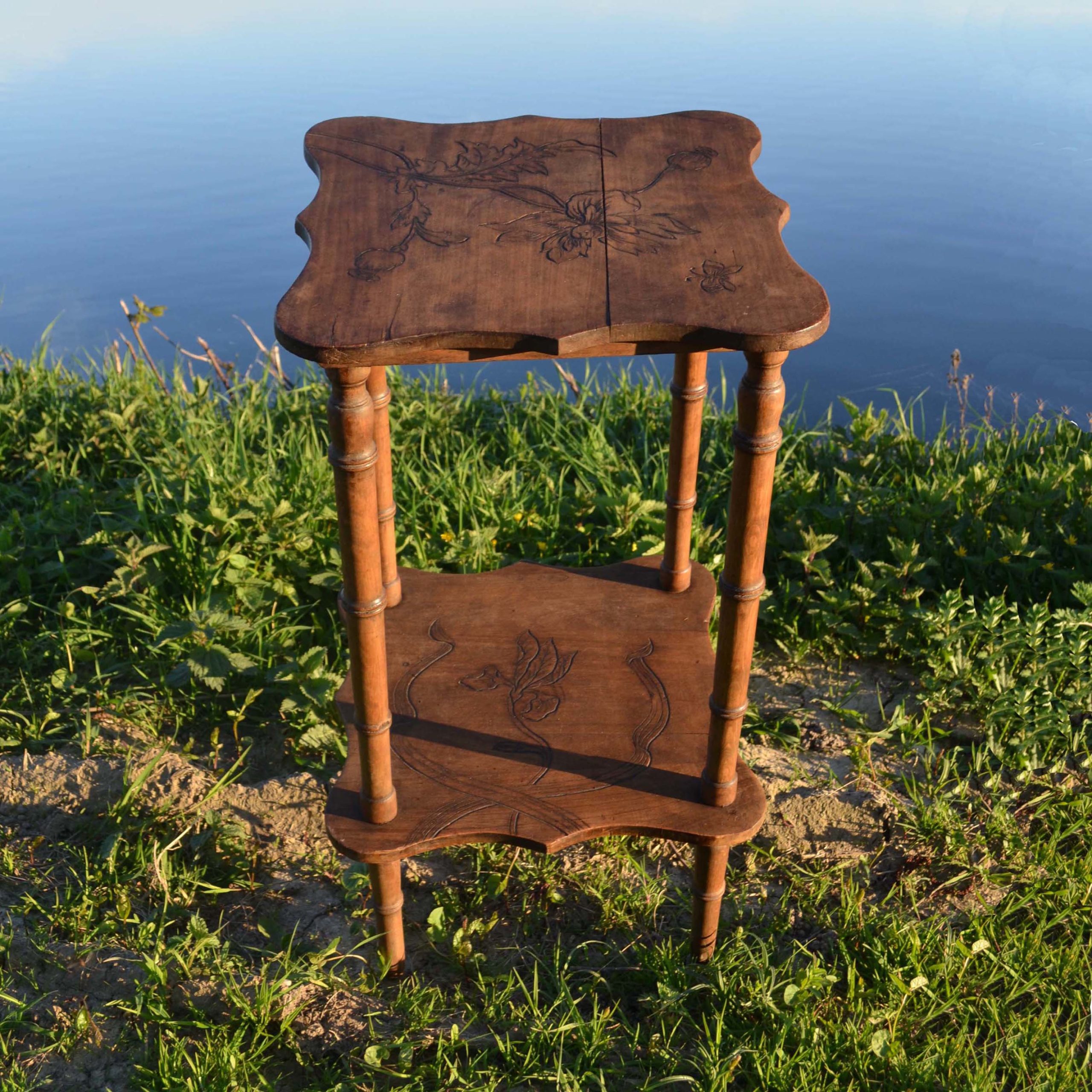 Petite table / sellette début du siècle avec pieds tournés. Style sobre. Le dessin floral gravé est légèrement 1900. Format 38x38cm, haut. 73cm
