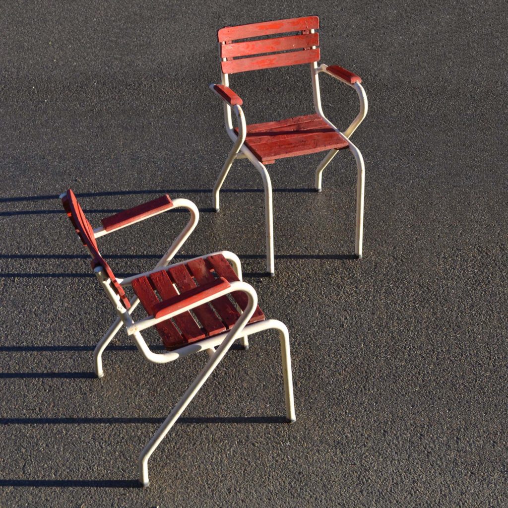 Paire de fauteuils d’extérieur au style des années 1950. Structure en tube avec accoudoirs. Lattage “bricolé” un peu usé, mais encore utilisable.