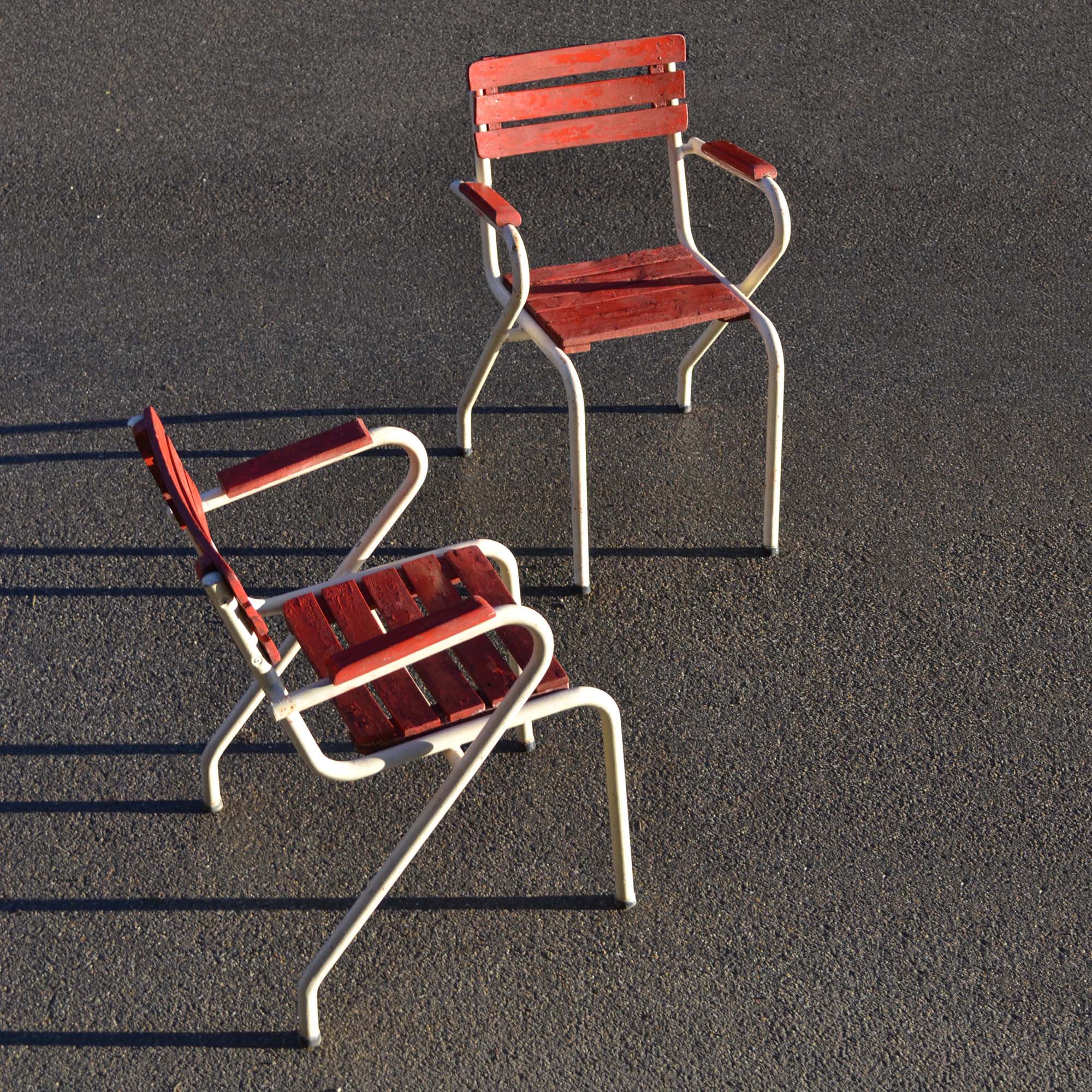 Paire de fauteuils d’extérieur au style des années 1950. Structure en tube avec accoudoirs. Lattage “bricolé” un peu usé, mais encore utilisable.