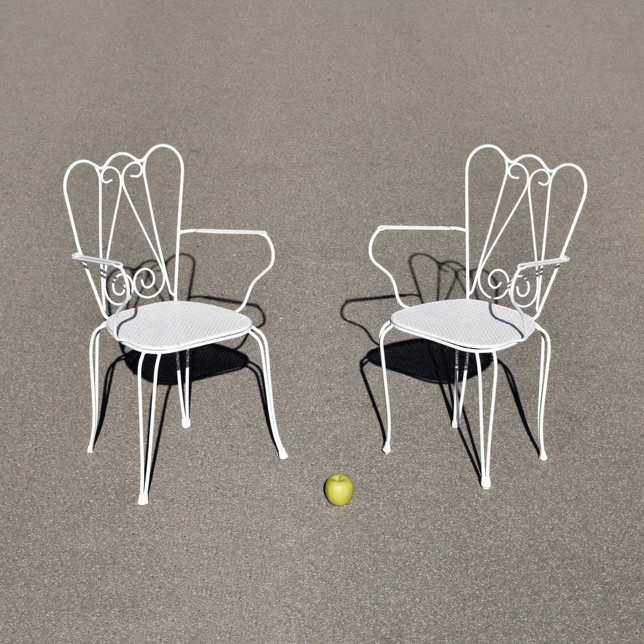 Paire d’anciennes chaises de jardin des années 1950 de style néoclassique peintes en blanc, assise en tôle perforée