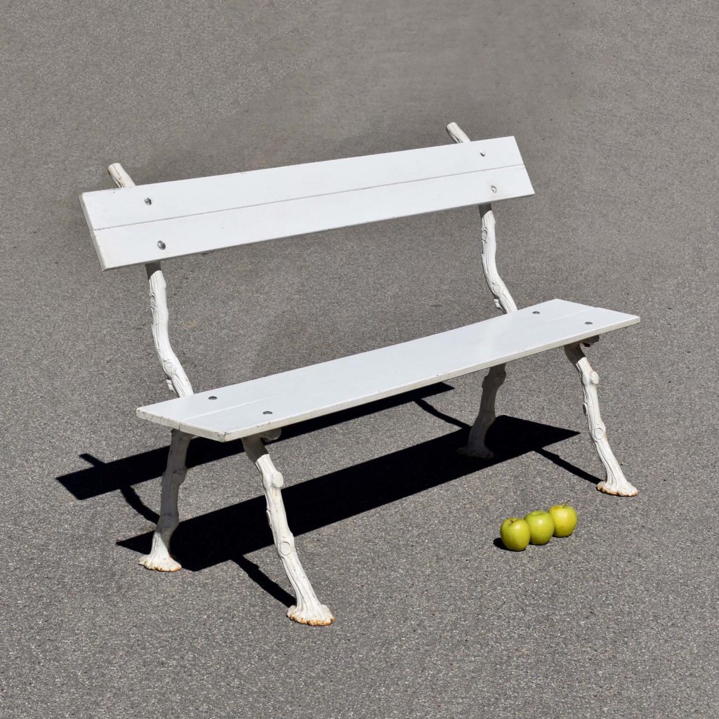 Petit banc de jardin, avec piètement en fonte, façon “fausse branche”. Et lattes en bois. Le tout peint en blanc. Style Shabby Chic brocante.