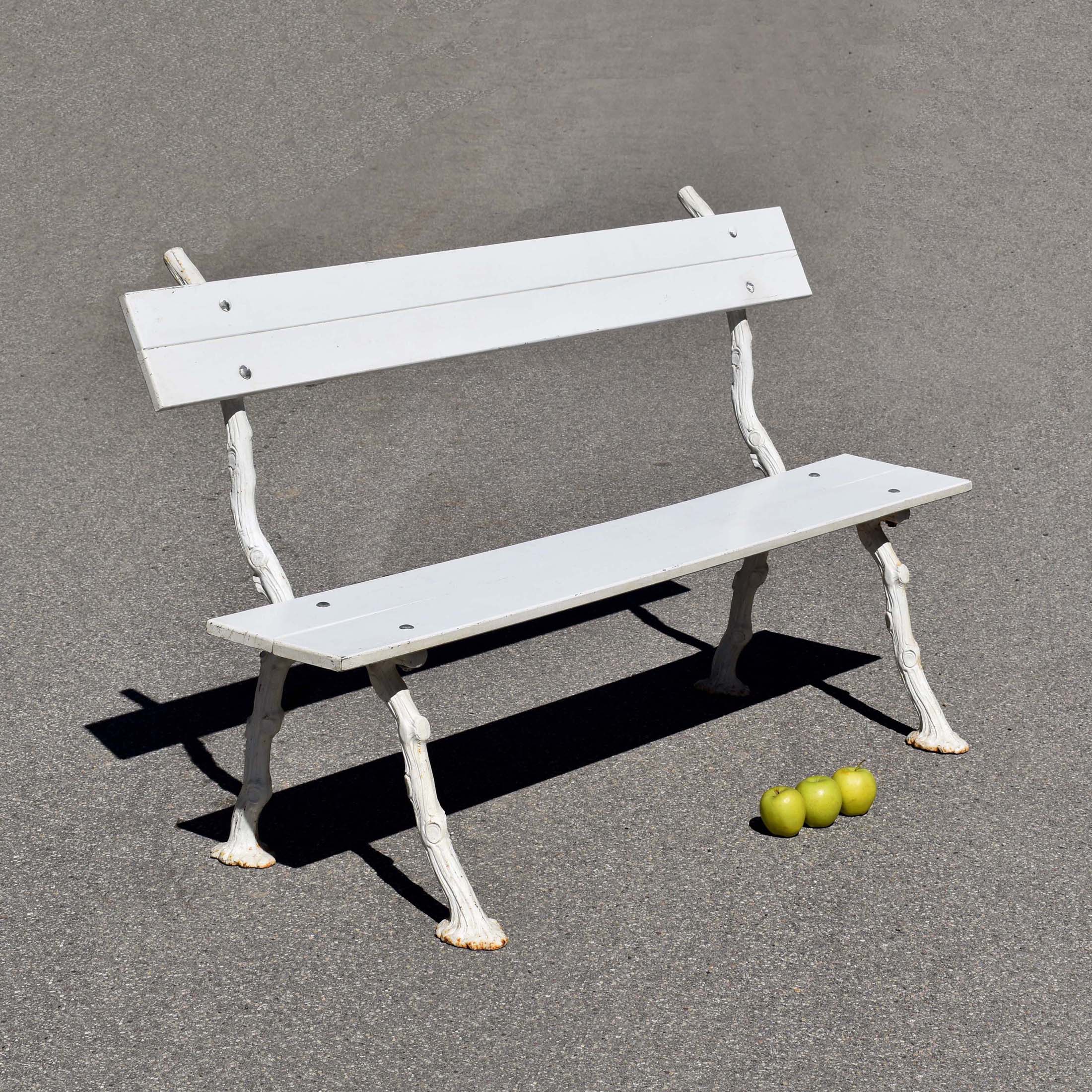 Petit banc de jardin, avec piètement en fonte, façon “fausse branche”. Et lattes en bois. Le tout peint en blanc. Style Shabby Chic brocante.