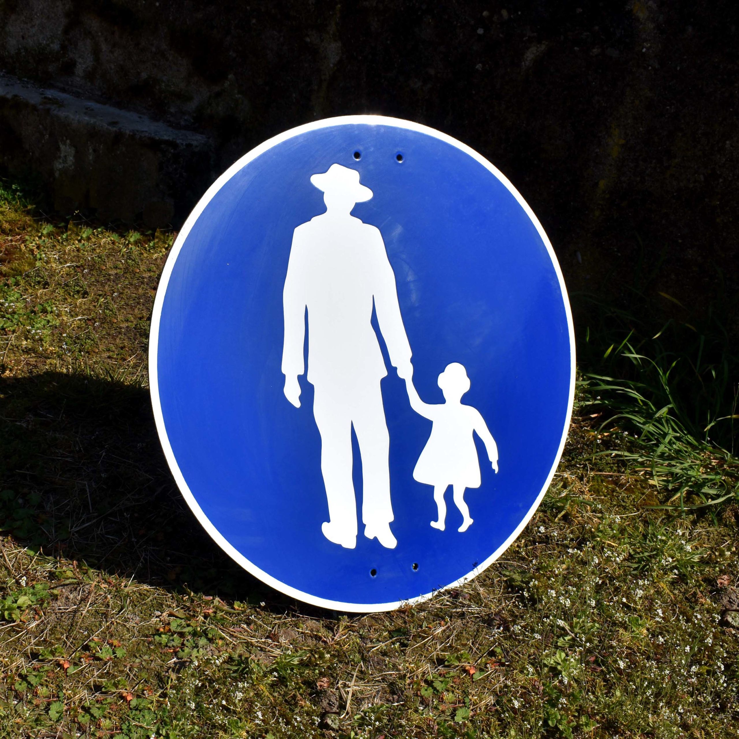Panneau pour indiquer un chemin pour les piétons. Avec pictogramme homme au chapeau et fillette. En tôle émaillée, peut-être d’origine Allemande.