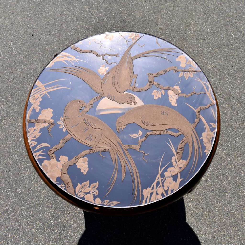 Plateau de table basse avec un verre miroité à décor d'oiseaux. Et piètement en bois. Avec plateau carré en dessous. Style typique des années 1940.