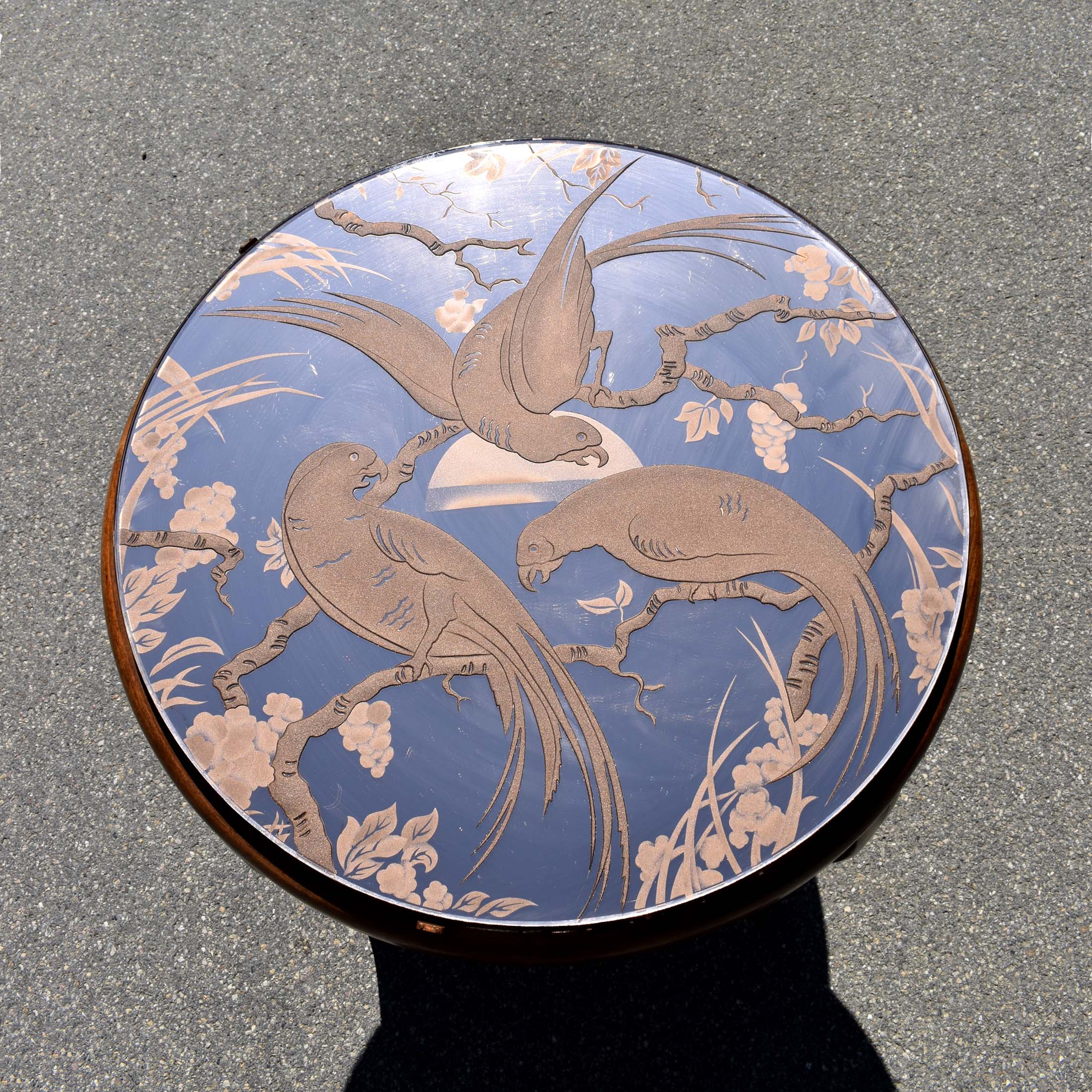 Plateau de table basse avec un verre miroité à décor d'oiseaux. Et piètement en bois. Avec plateau carré en dessous. Style typique des années 1940.