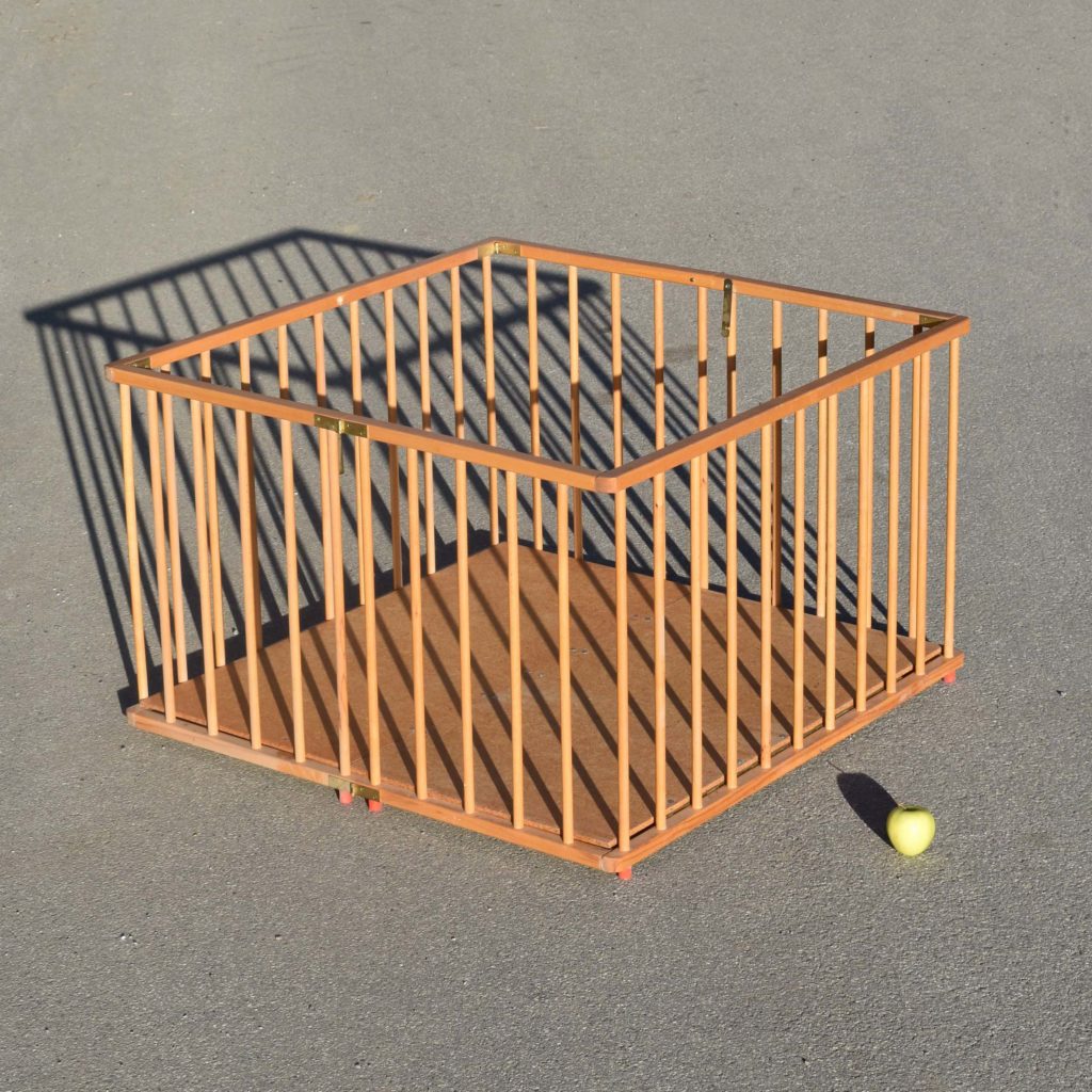 Parc pour bébé vintage seventies pliant avec barreaux en bois. Modèle pliable avec fond en panneau, couleur naturelle.