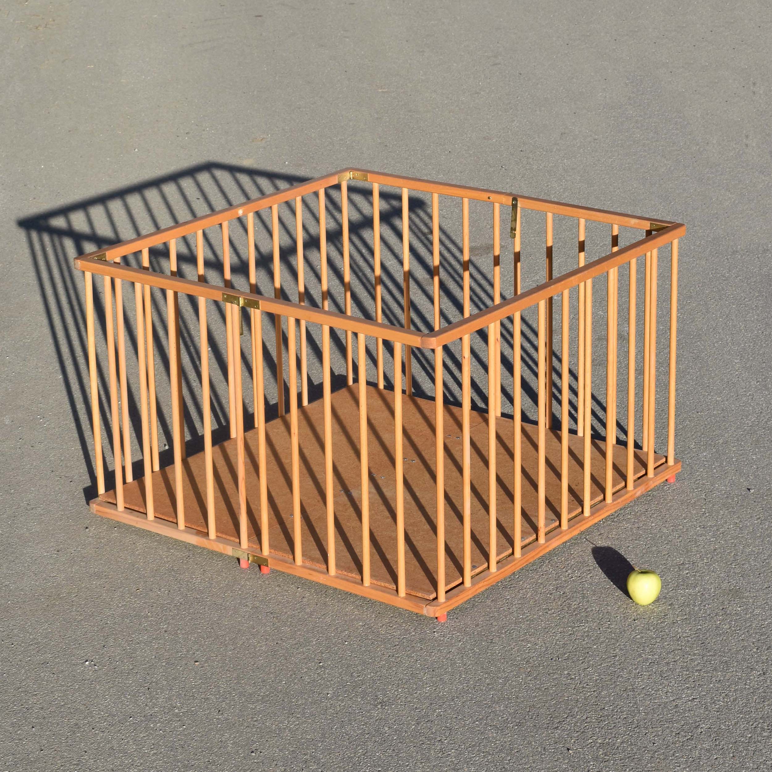 Parc pour bébé vintage seventies pliant avec barreaux en bois. Modèle pliable avec fond en panneau, couleur naturelle.
