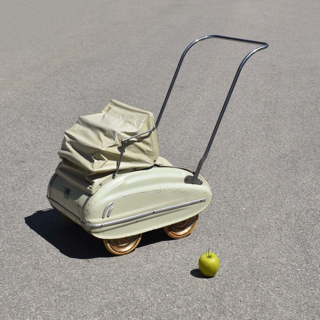 Poussette de poupée de marque Helvétia des années 1950. Caisse en tôle, couleur beige pistache vert pale. Avec capote pliante.