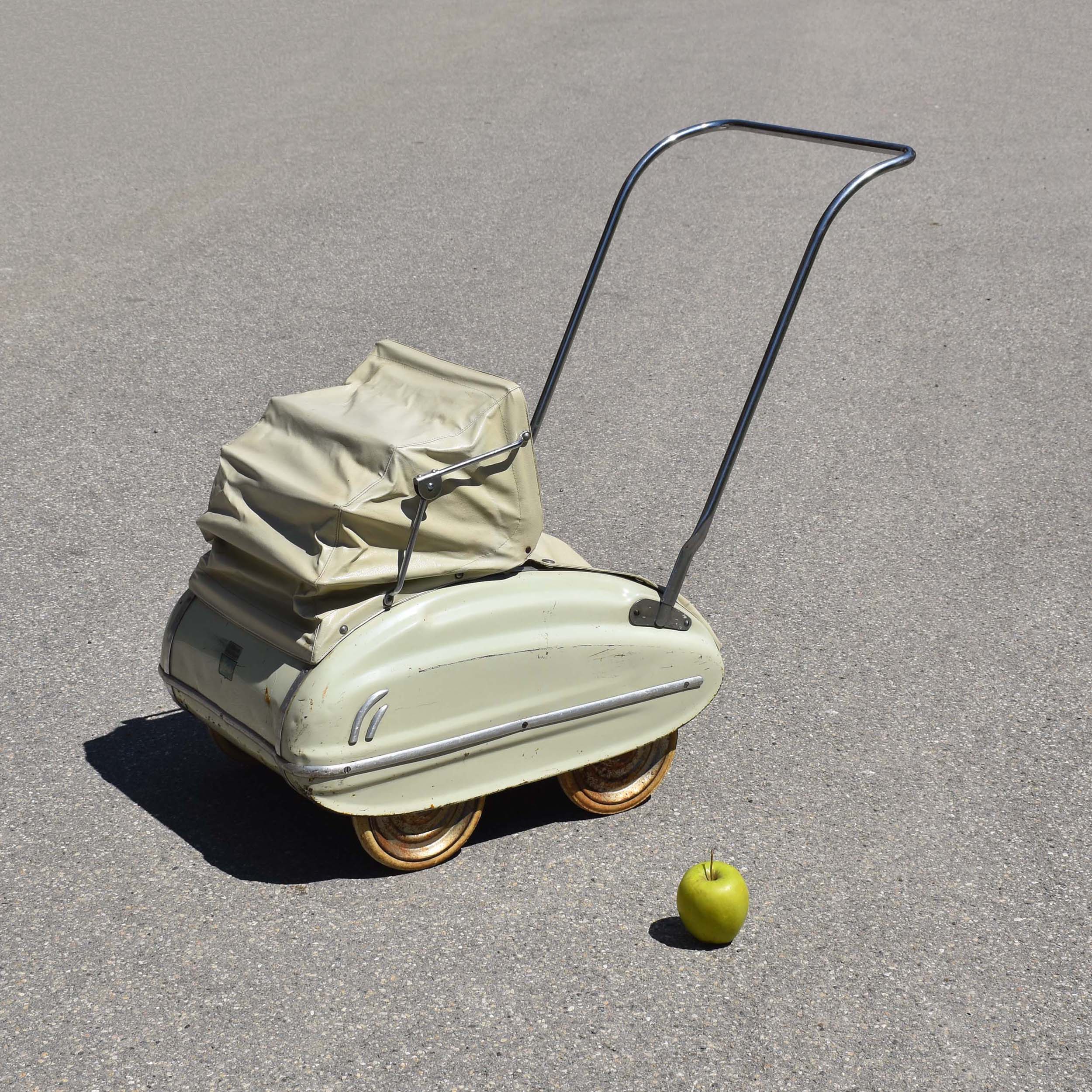 Poussette de poupée de marque Helvétia des années 1950. Caisse en tôle, couleur beige pistache vert pale. Avec capote pliante.