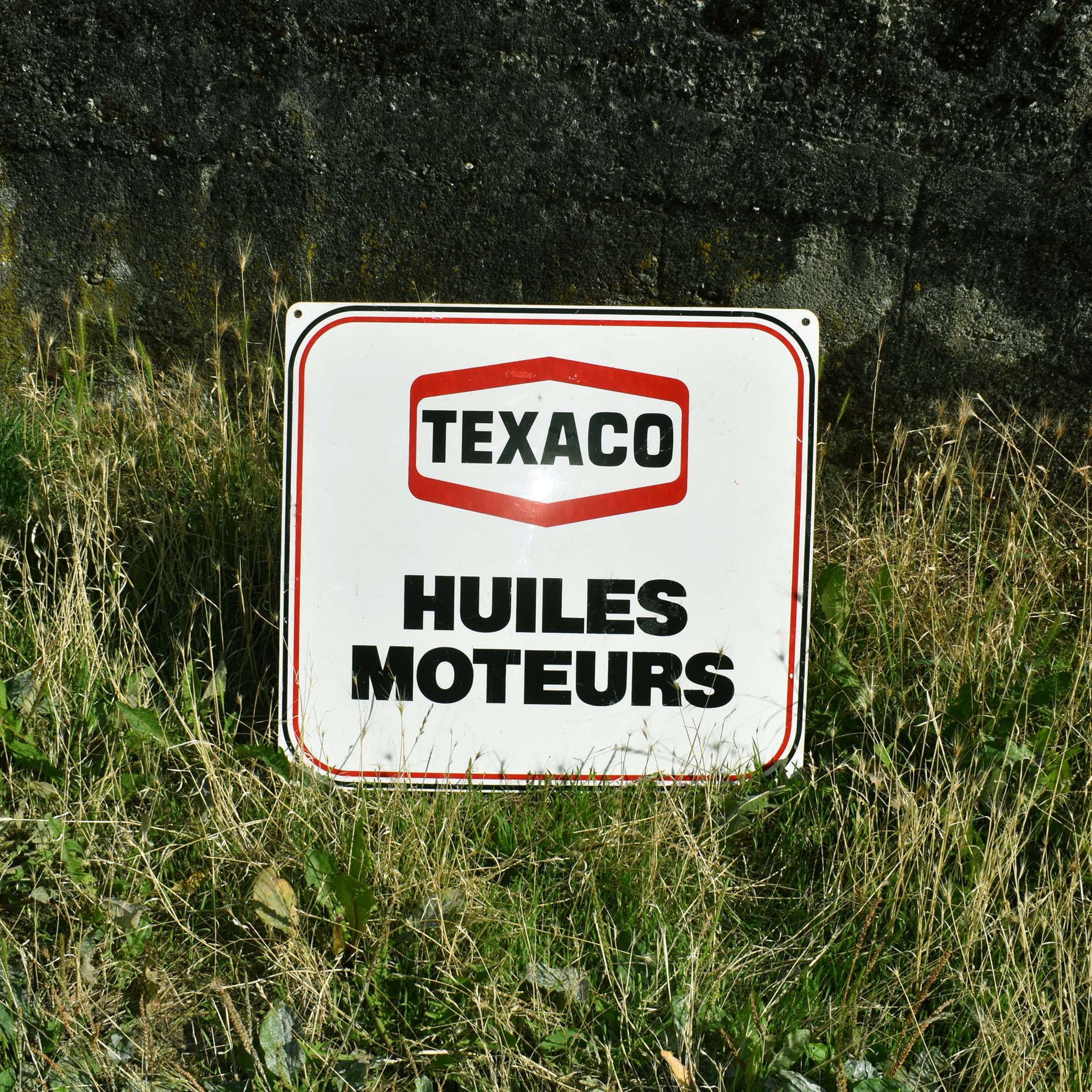 Enseigne de garage des années 1970. Pour les huiles moteur Texaco. Ce logo avec le losange a été en service de 1963 à 1981.