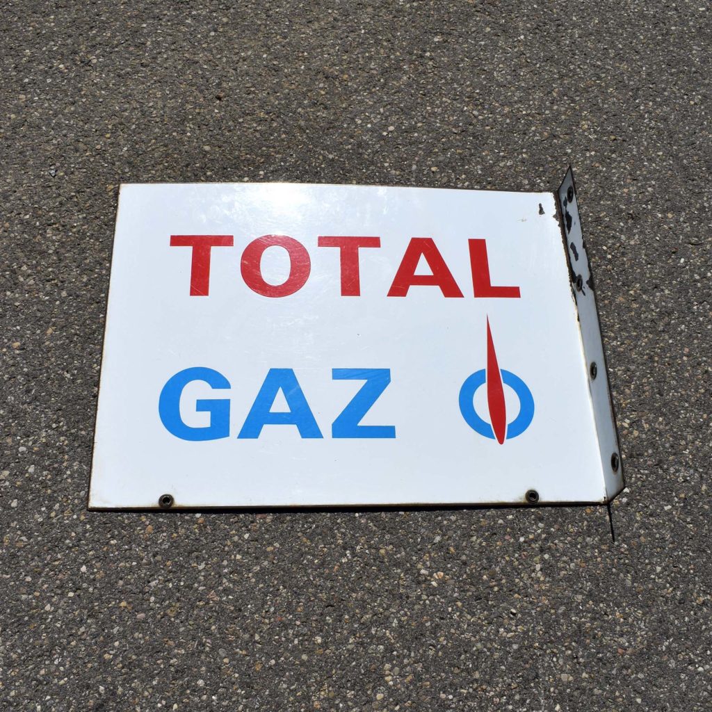 Enseigne en potence en tôle émaillée double face. Pour un dépositaire de bonbonnes de gaz Total. Émaillerie Vitracier Neuhaus, et daté 1965. Logo avec la “flamme”