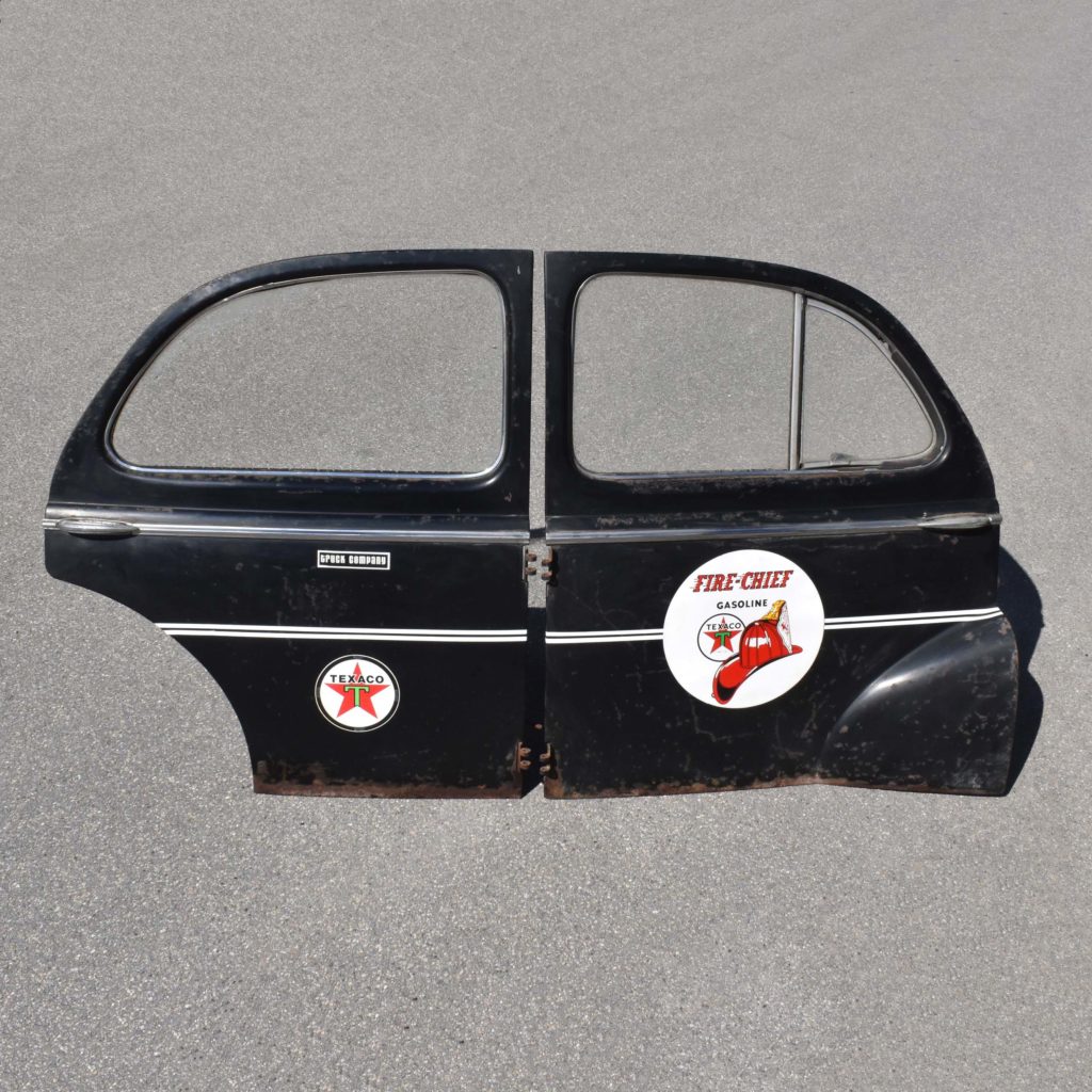 Anciennes portières automobile au look des années 1940. Pièces détachées d'une voiture Peugeot 203. Avec stickers Texaco pour déco garage vintage.