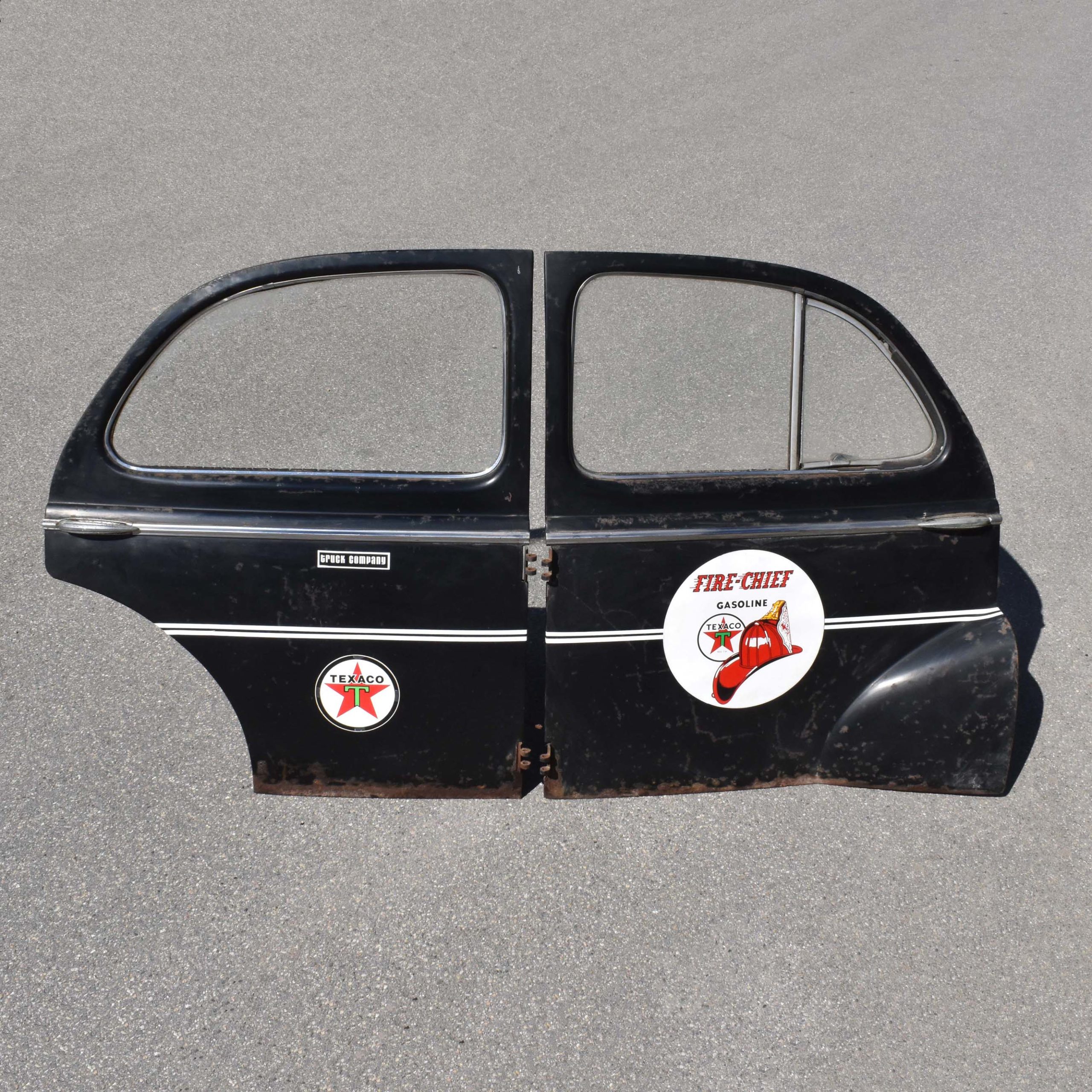 Anciennes portières automobile au look des années 1940. Pièces détachées d'une voiture Peugeot 203. Avec stickers Texaco pour déco garage vintage.