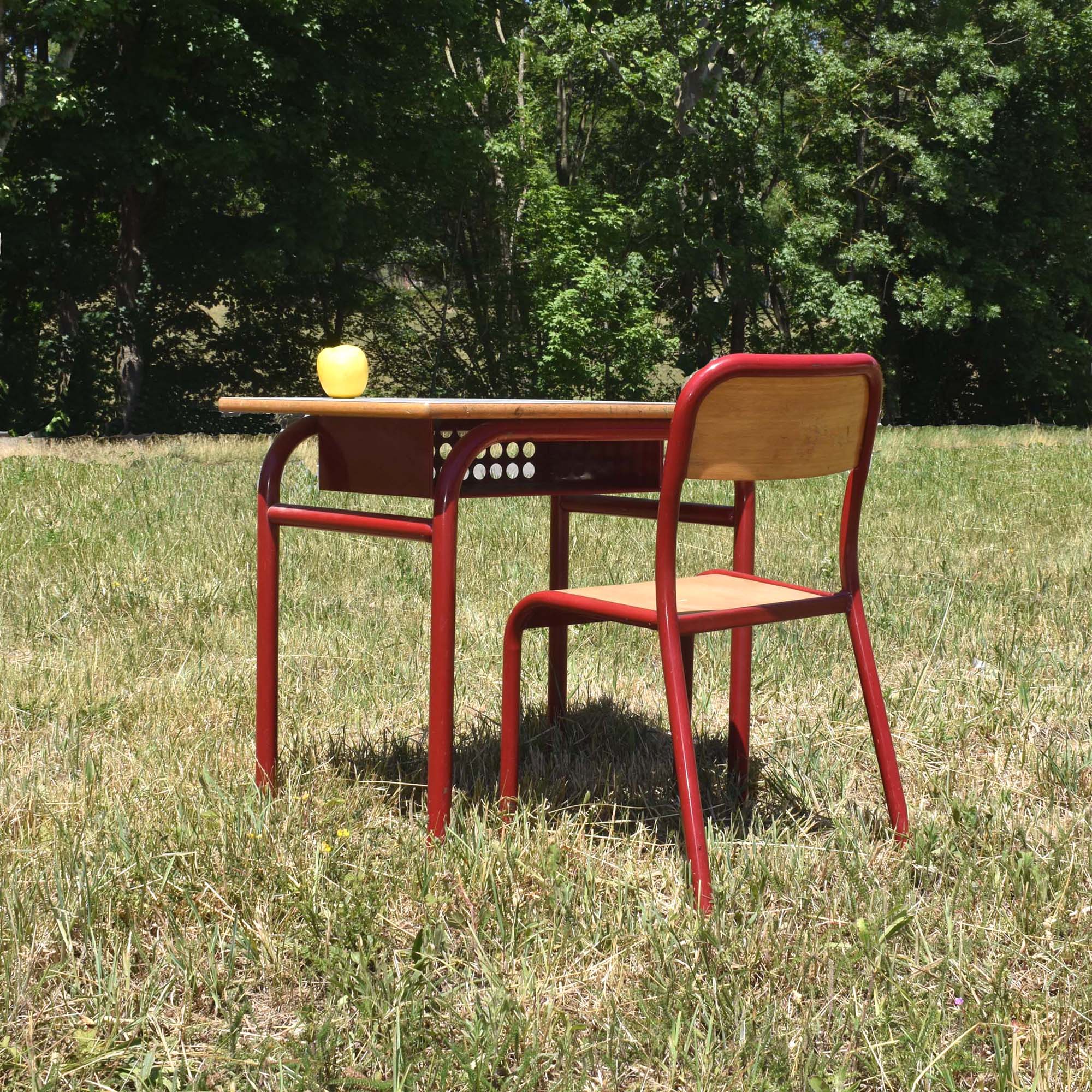 pupitre d'école française des années 1970 avec sa chaise en métal couleur rouge bordeaux. Petit bureau et siège scolaire seventies.
