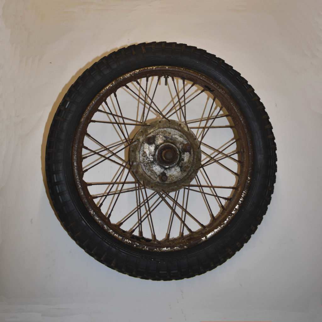 Vieille roue de moto non identifiée des années 1950 à 60. Axe déporté, peut-être pour sidecar. Pièce détachée ancienne.