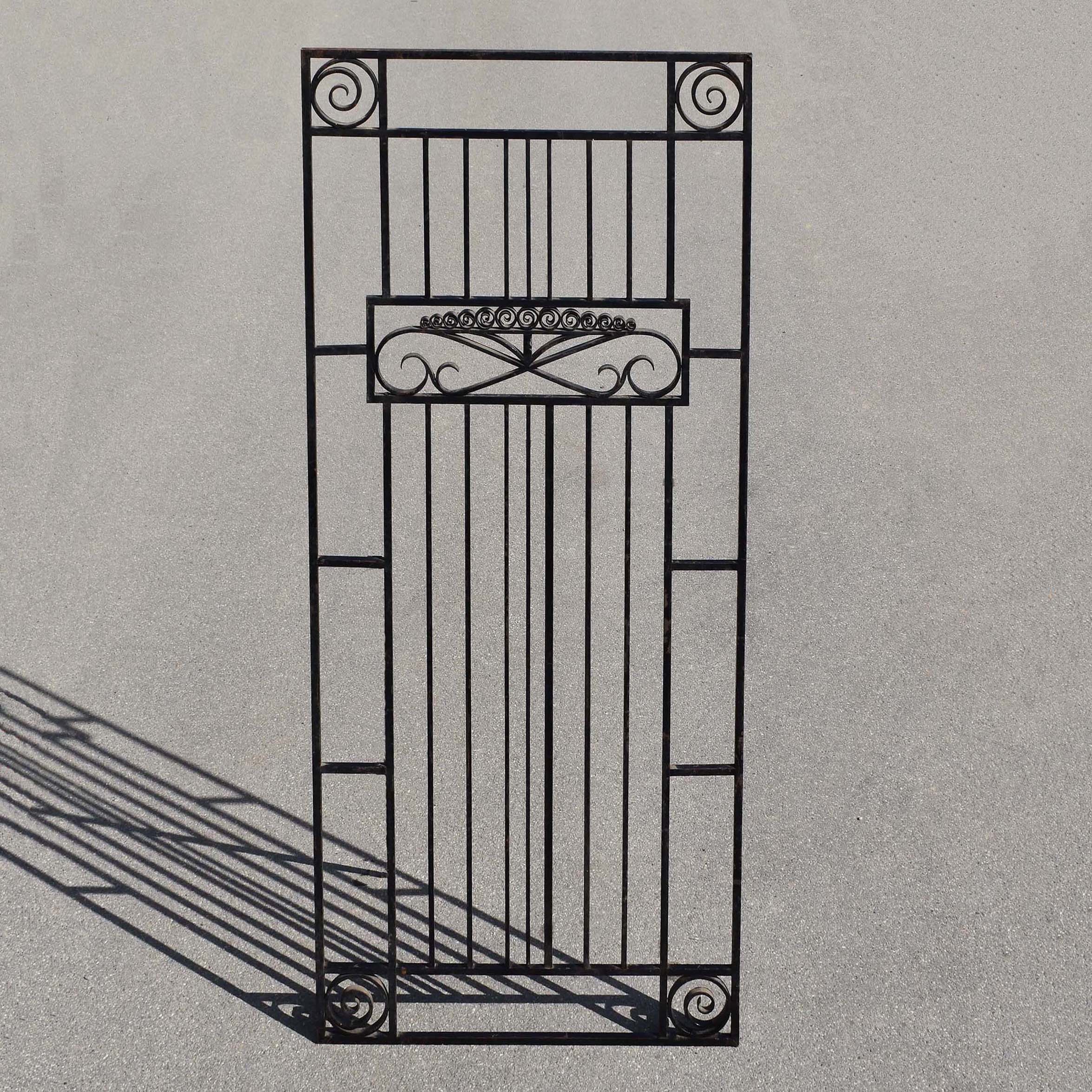 Grande grille Art-Déco en fer forgé style sobre et harmonieux, vers 1930. Format 85x195cm. En fer plat et carré avec motifs à volutes.