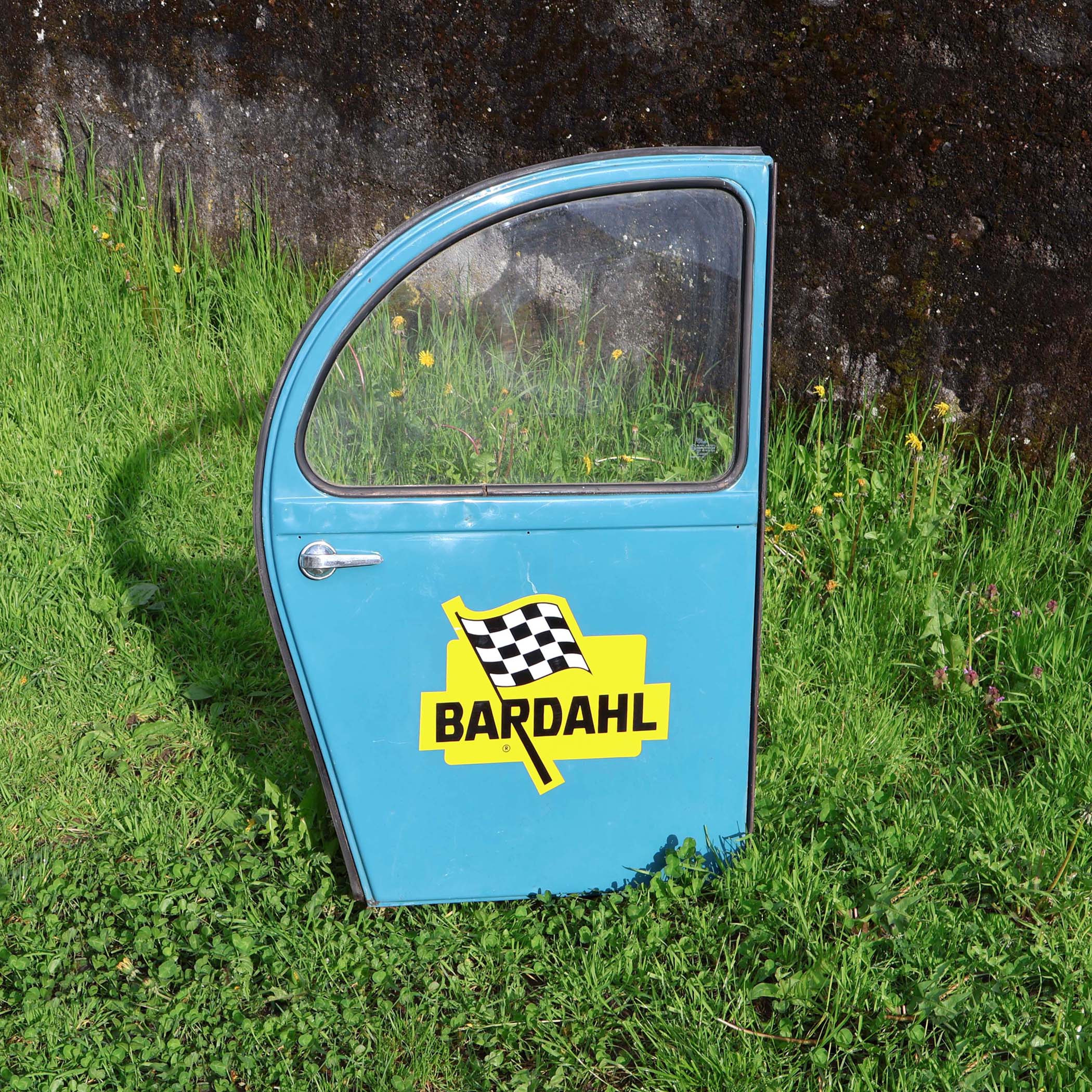 Vieille portière arrière de Citroën 2cv bleue. Avec sticker Bardahl. De la marque américaine d'additif pour l'huile moteur.