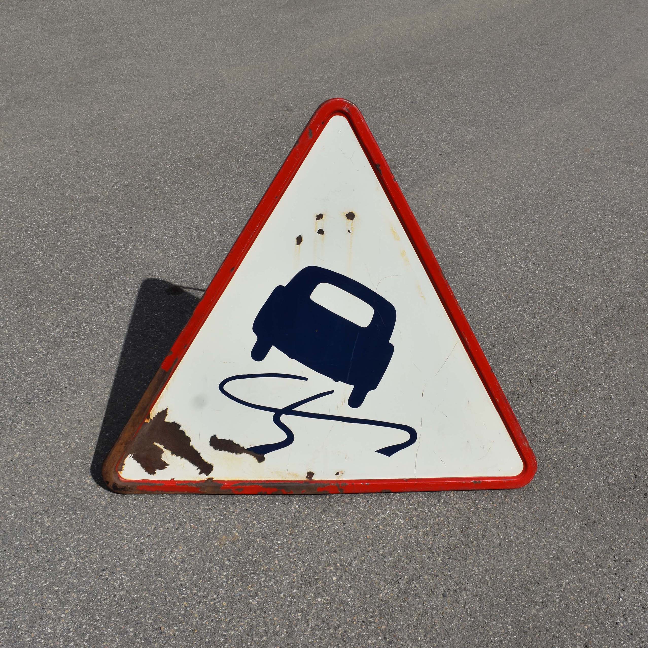 Ancien panneau de signalisation français: “Attention route glissante / verglas” daté de 1953. Avec dessin / pictogramme d’une voiture qui glisse.