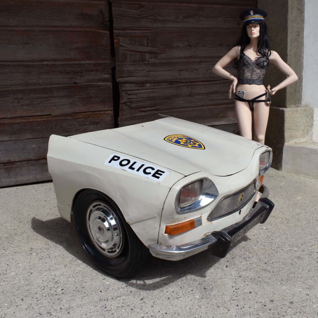 Face avant demi voiture découpée. Déco de bar. Ami 8 Citroën. Calandre avec ailes et capot. Stickers décor de police américaine. Avec mannequin policière sexy.