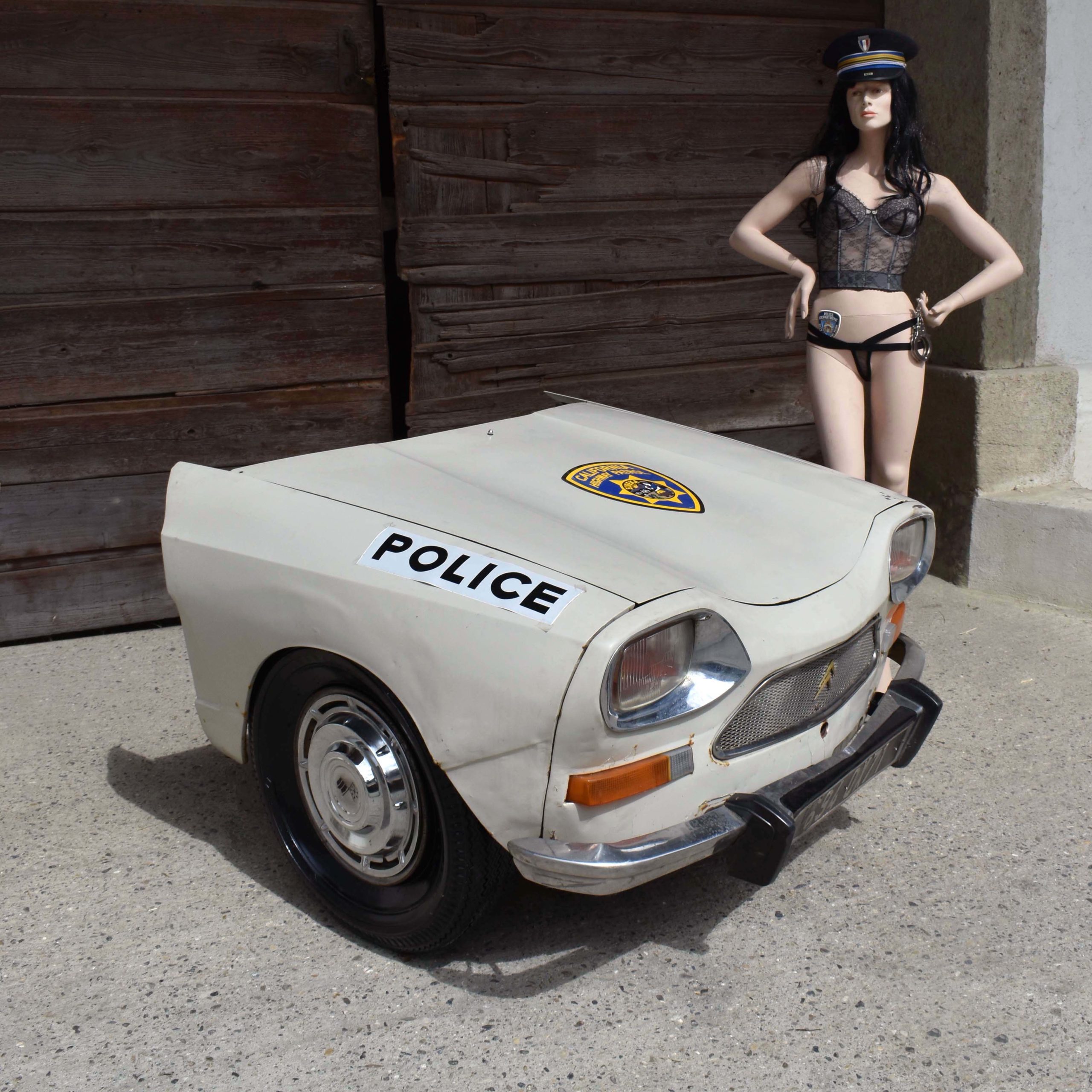 Face avant demi voiture découpée. Déco de bar. Ami 8 Citroën. Calandre avec ailes et capot. Stickers décor de police américaine. Avec mannequin policière sexy.