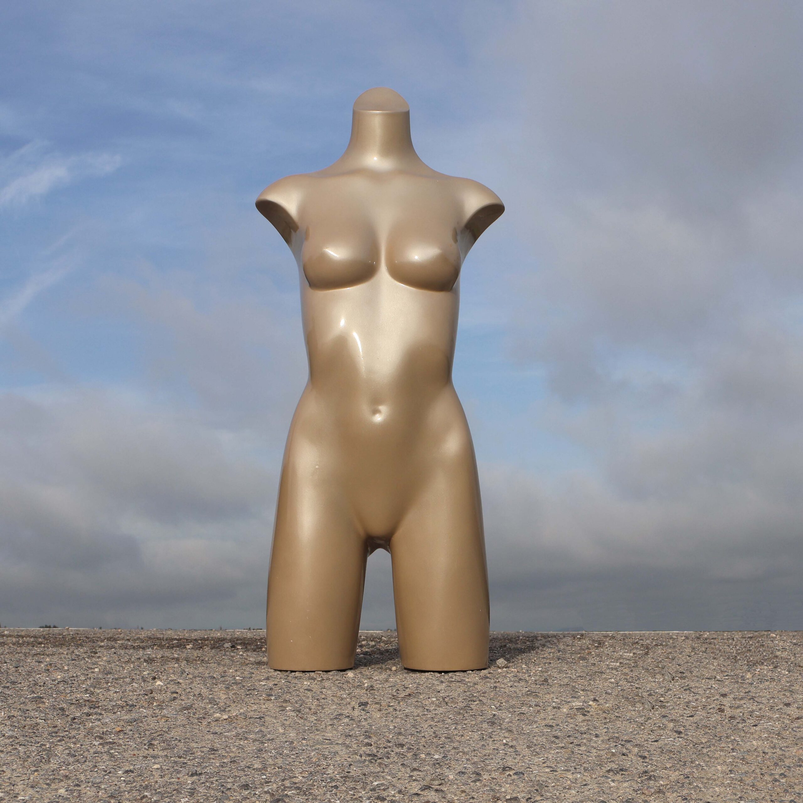 Buste de mannequin de vitrine femme. Avec une partie des jambes. Modèle d'occasion, de couleur beige métallisé.