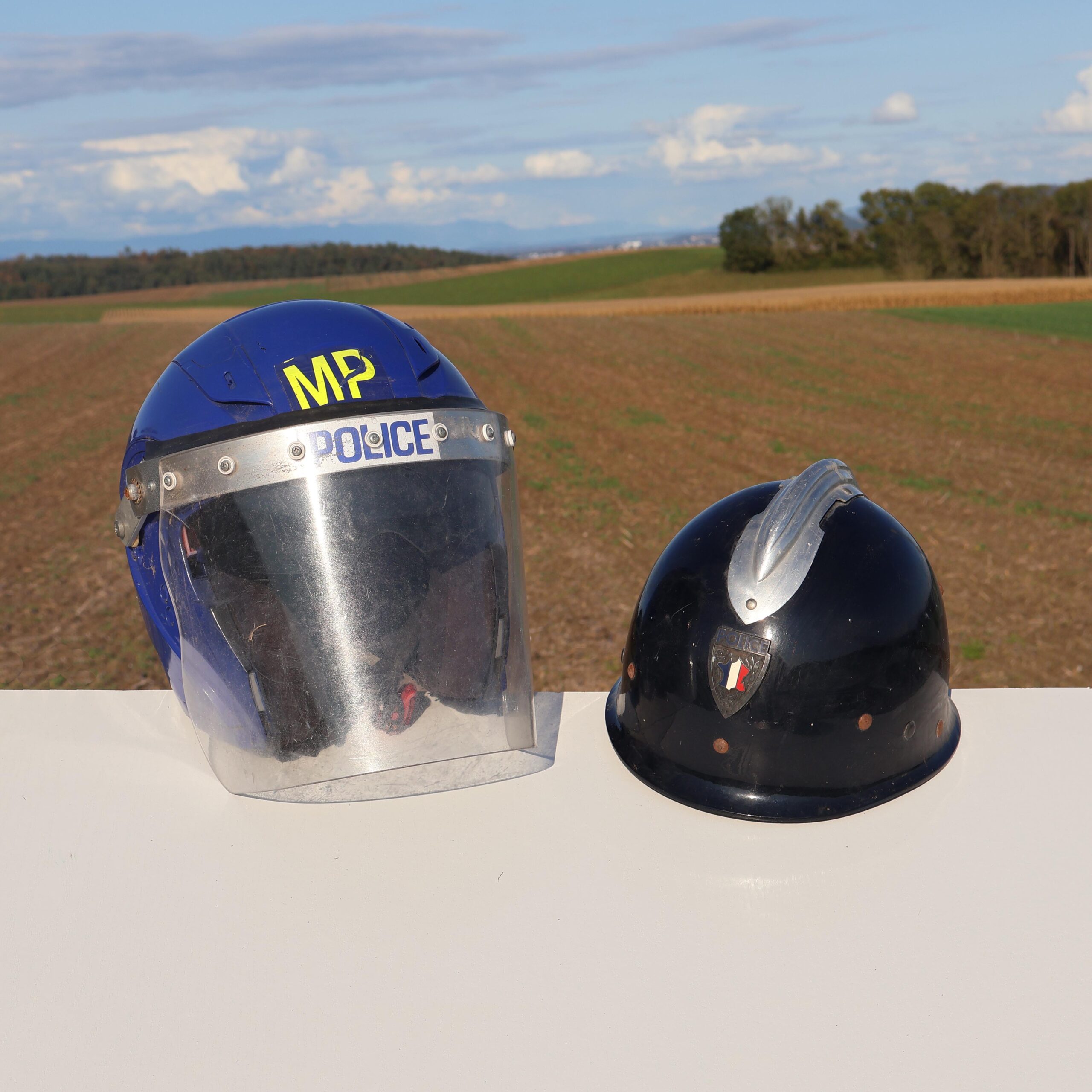 Casque de maintien de l'ordre / anti-émeute. Un modèle Anglais, de couleur bleue, marquage police sur la visière. Et casque Français modèle M 1953bis. De Petitcollin année 1961. Souvent appelé Mai 68