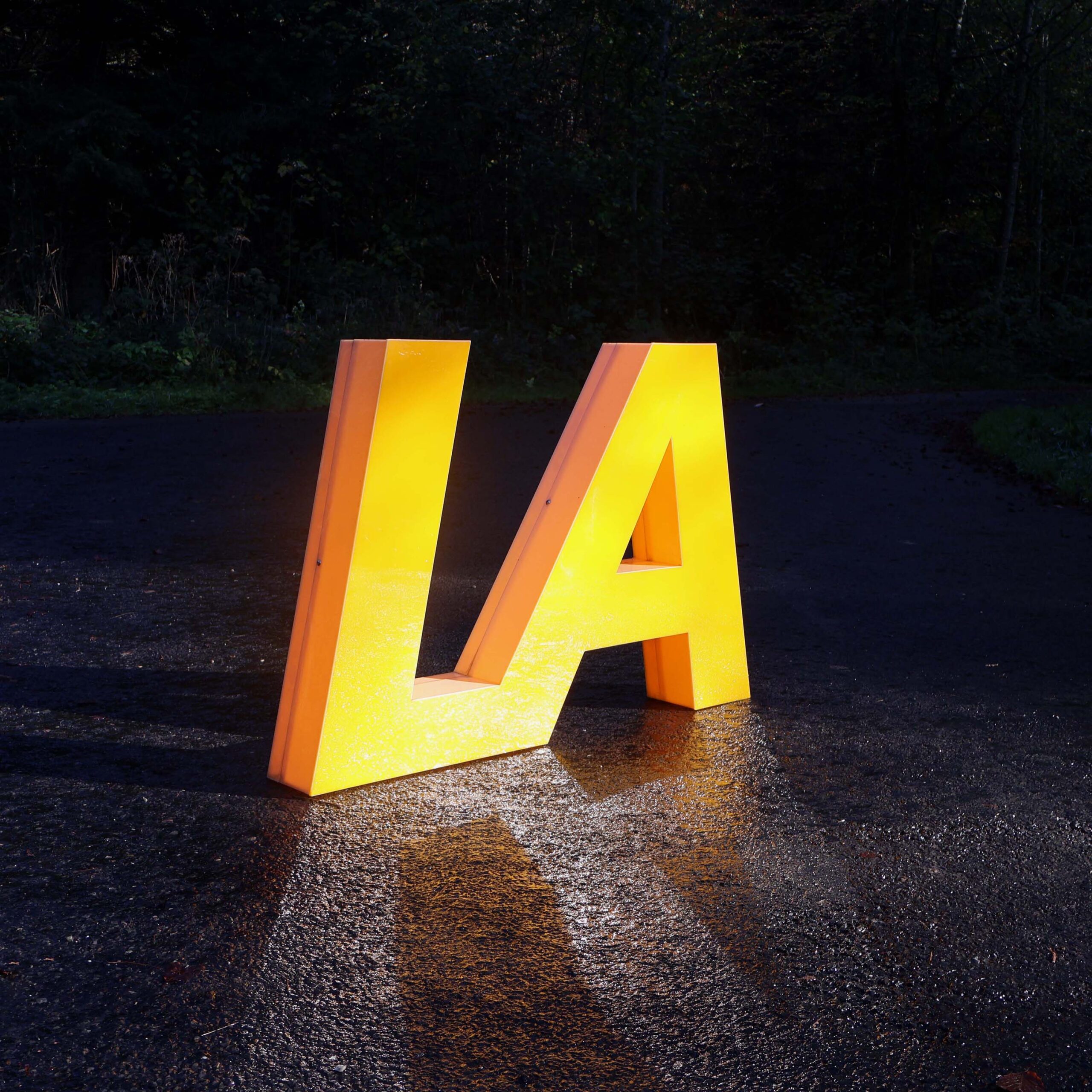 Lettres lumineuses vintage en plastique jaune orangé LA appondu. Les 2 lettres L et A, sont ensembles, et ne forment qu'un seul bloc. Hauteur 65cm.