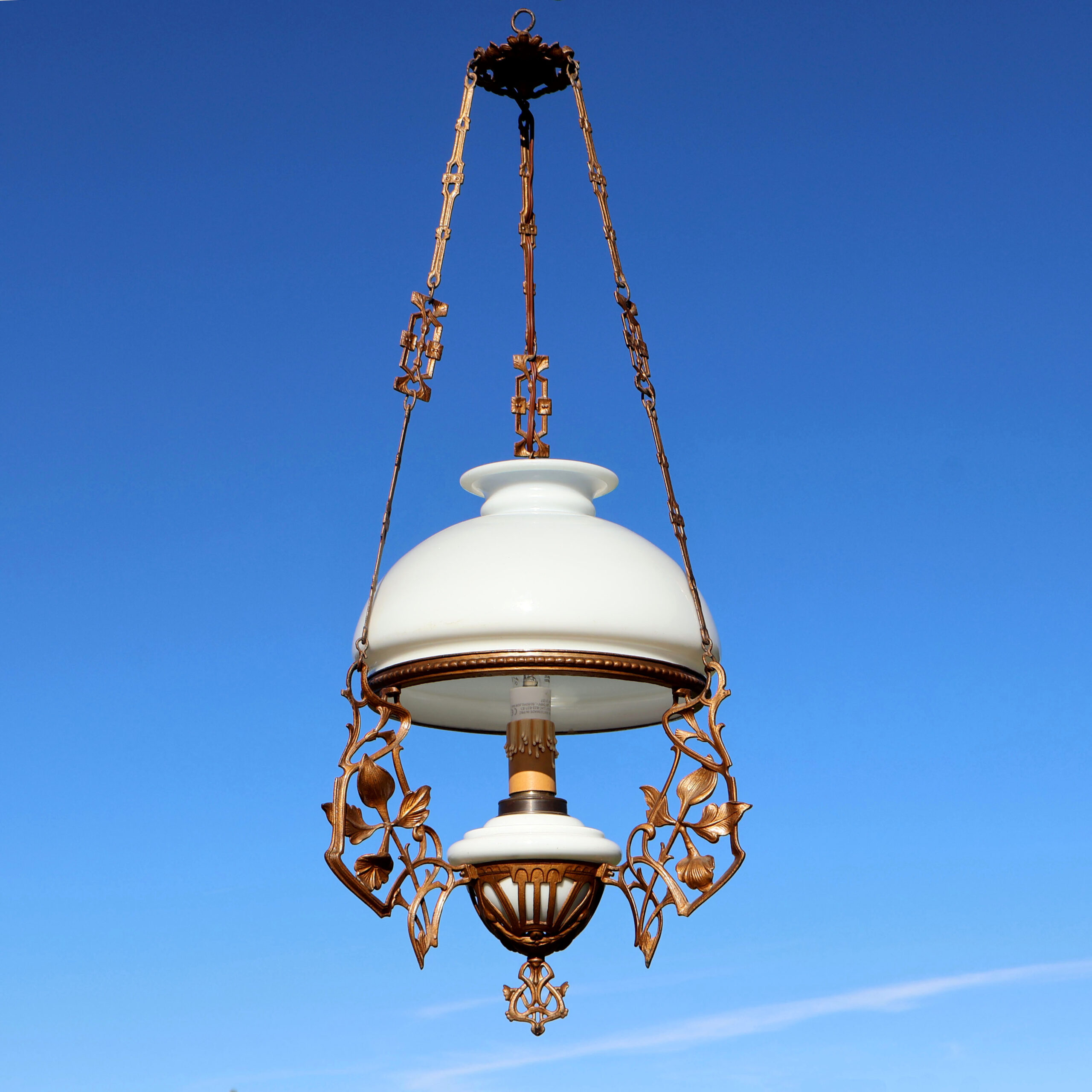 Ancien lustre lampe suspension d'époque et de style Art-Nouveau. Avec opaline blanche en verre, et motifs végétaux entrelacés en métal doré, finition bronze.