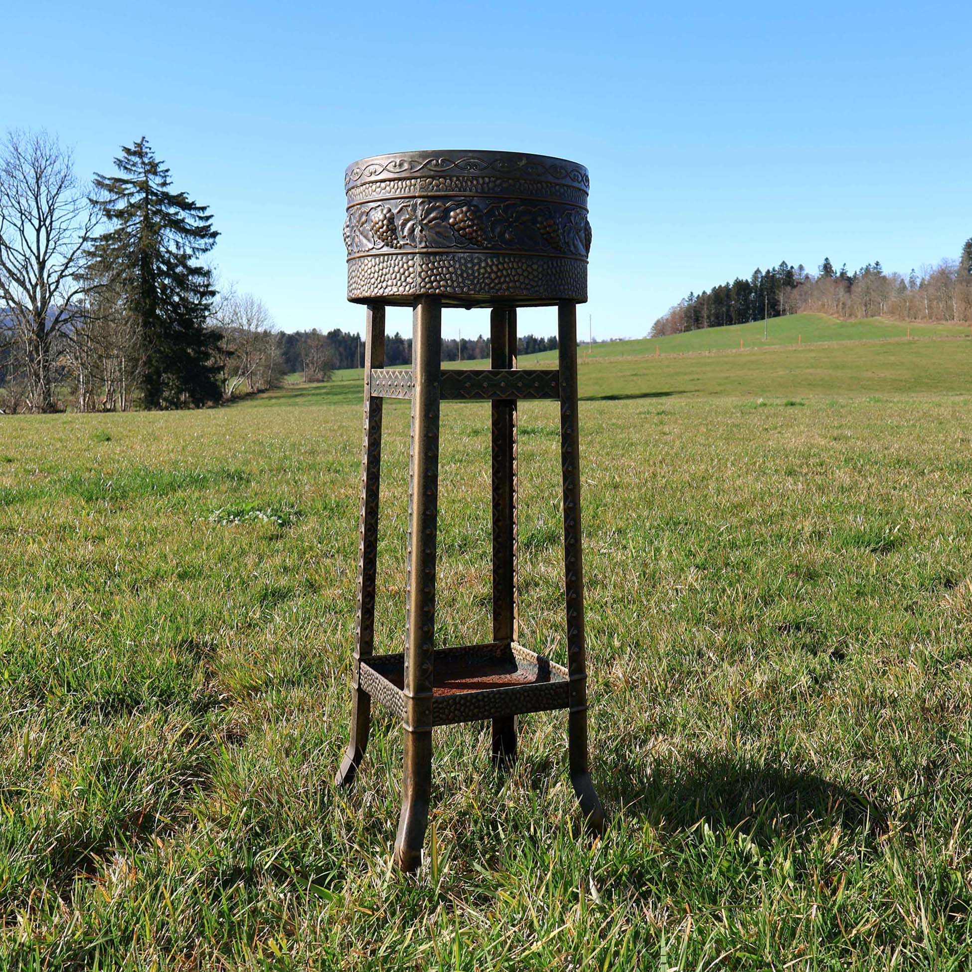 Jardinière support de pot de fleurs en tôle emboutie. D'époque Art-Déco des années 1930. Avec frise circulaire à décor de grappes de raisin et feuilles de vigne.