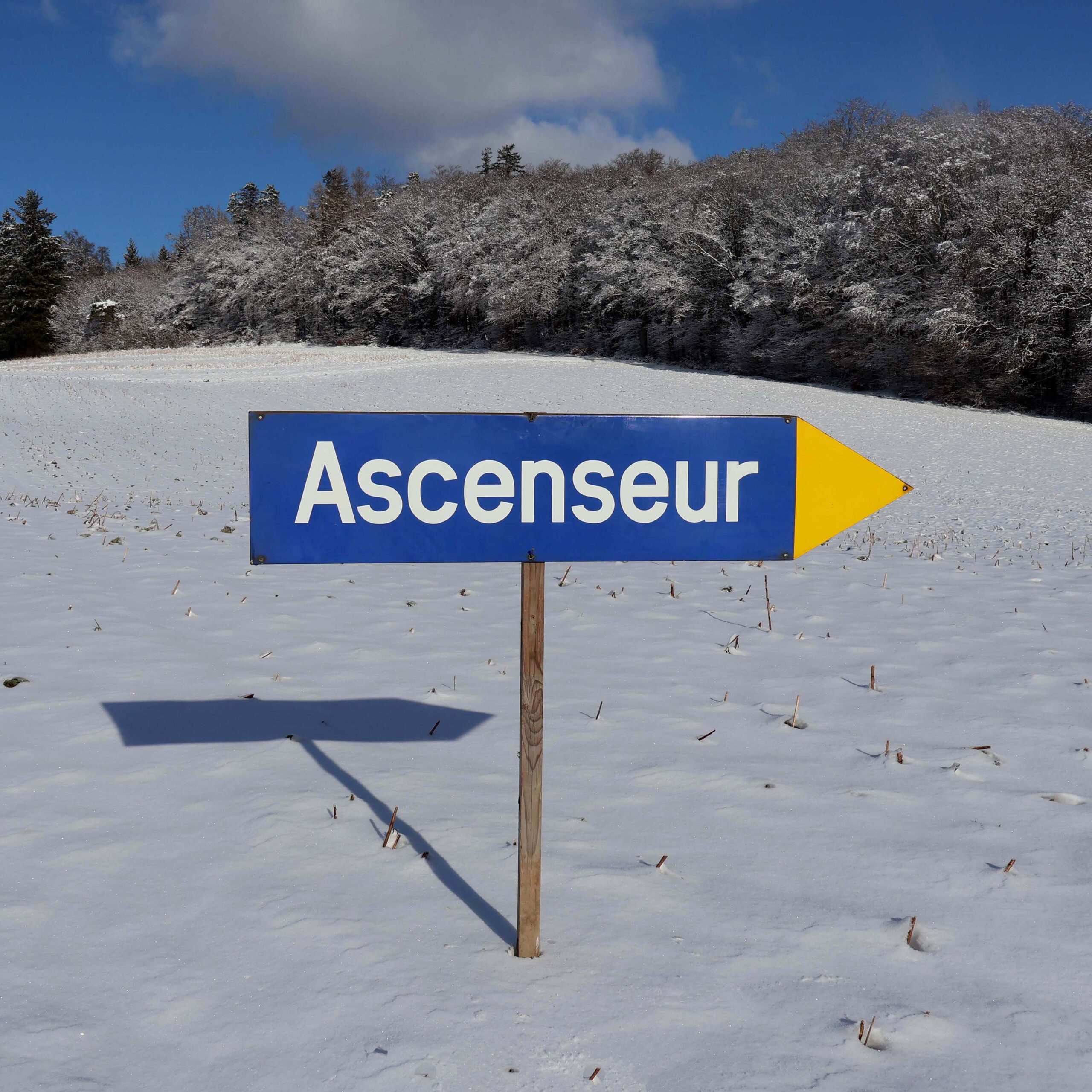 Panneau en tôle émaillée direction ascenseur de gare CFF Suisse. Flèche directionnelle. Émaillé bleu, avec bout triangle jaune. Lettrage blanc ascenseur.