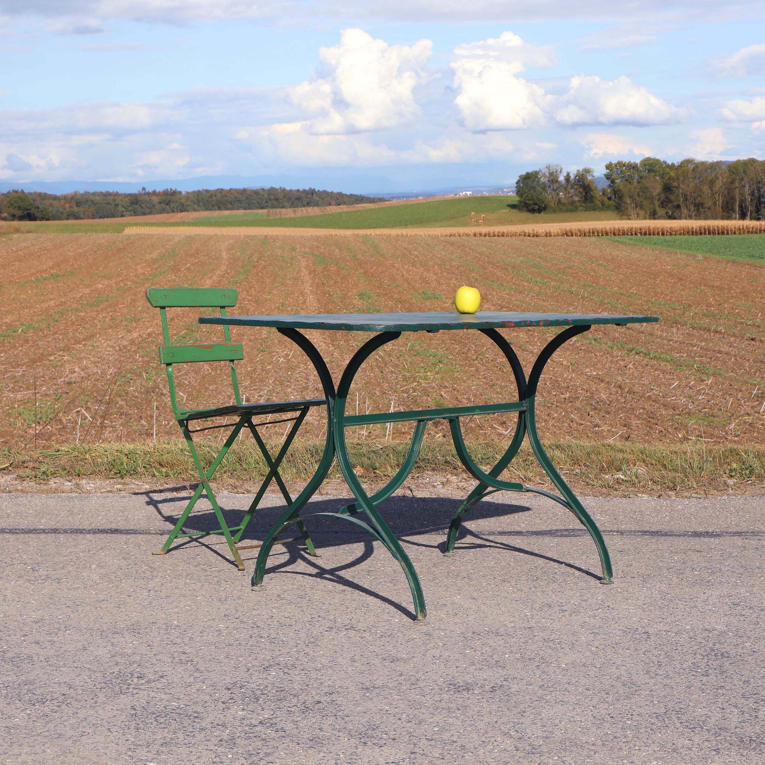 Table de terrasse de café Suisse des années 1920. Probablement de marque Bigla. De couleur verte, avec piètement en fer T cintré.